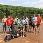 Group of volunteers by St. Croix River and garbage they cleaned up