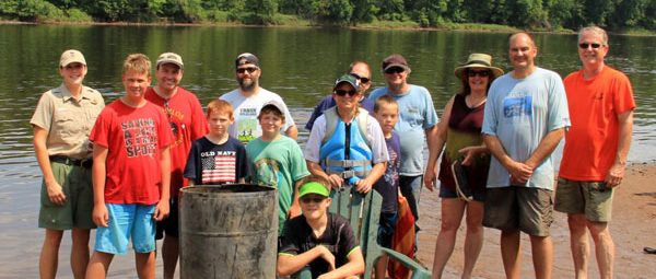 Group of volunteers by St. Croix River and garbage they cleaned up