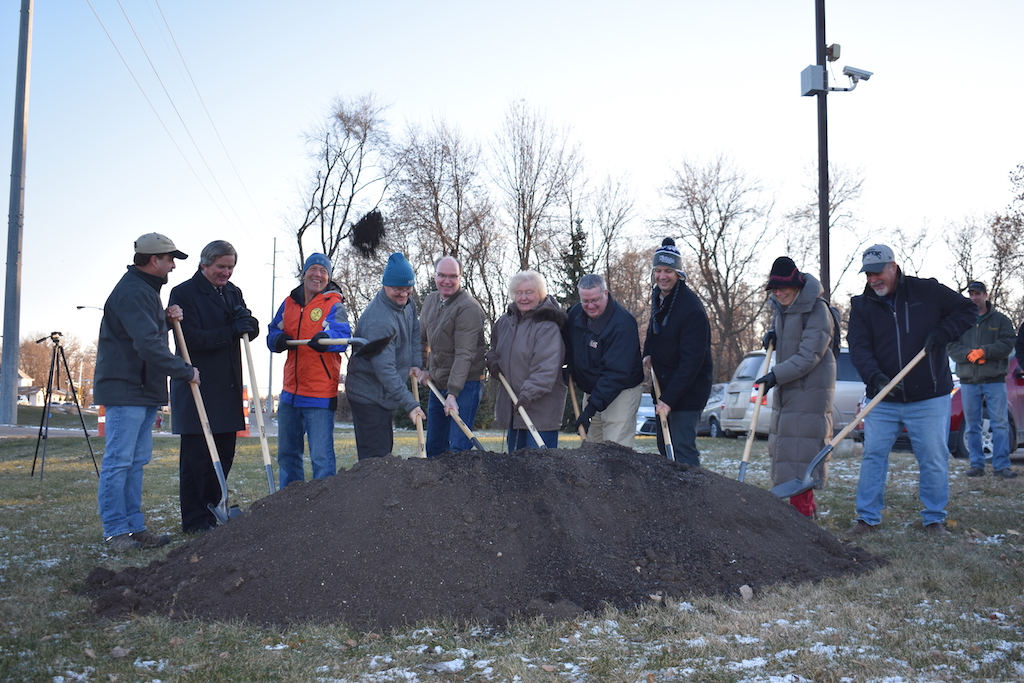 Ten people dig their shovels into a pile of dirt for the ground breaking ceremony