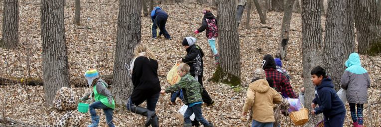 kids running into the woods to find easter eggs