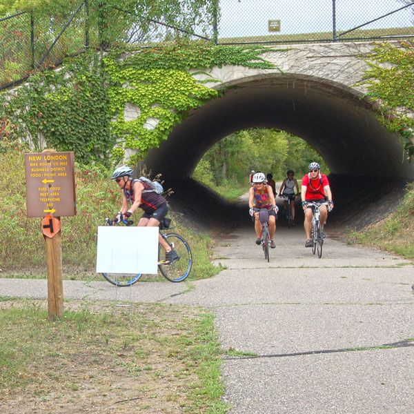 Bicyclists going through tunnel on Glacial Lakes State Trail in New London