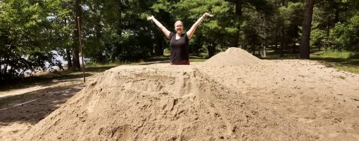 woman stands behind pile of volleyball sand