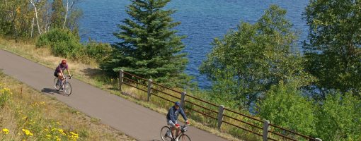 bicyclists on Gitchi Gami with Lake Superior in back