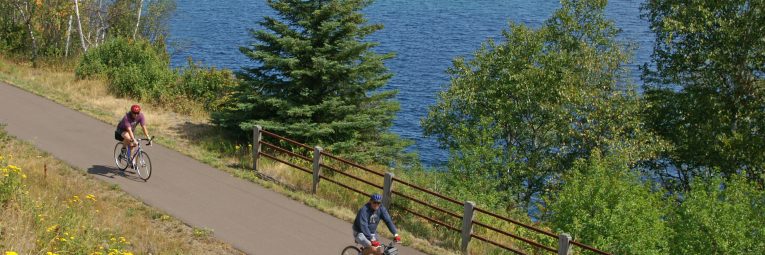 bicyclists on Gitchi Gami with Lake Superior in back