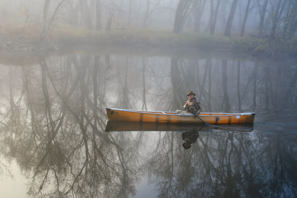 Man in canoe on misty river