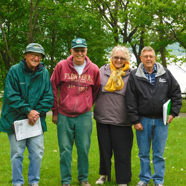 four members of the Assoc. standing in grass at Frontenac
