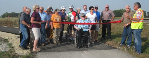 Group cutting ribbon on new segment of Shooting Star State Trail