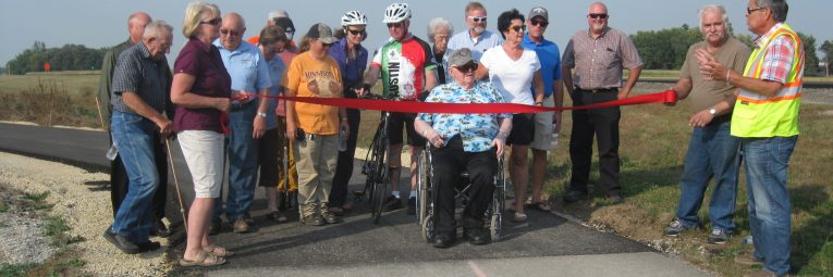 Group cutting ribbon on new segment of Shooting Star State Trail
