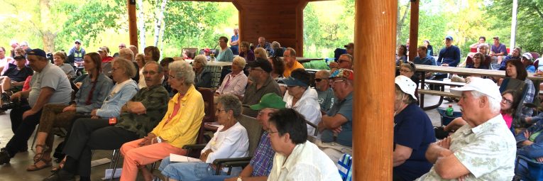 a crowd in the picnic shelter enjoys the music