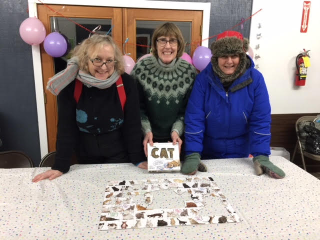 three women doing a cat puzzle