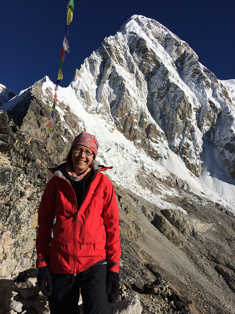 Anne Flueckiger in Nepal mountains with Tibetan flags