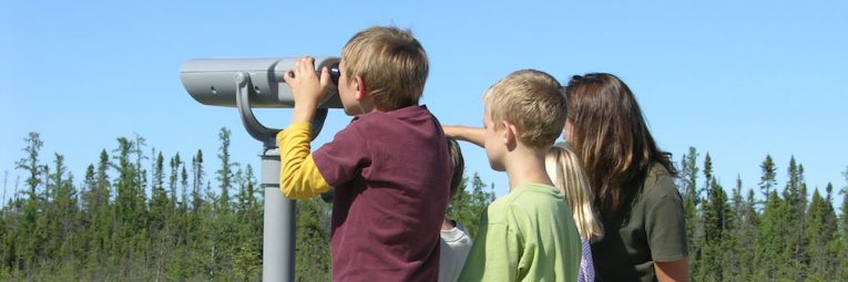 kids looking over bog through binoculars