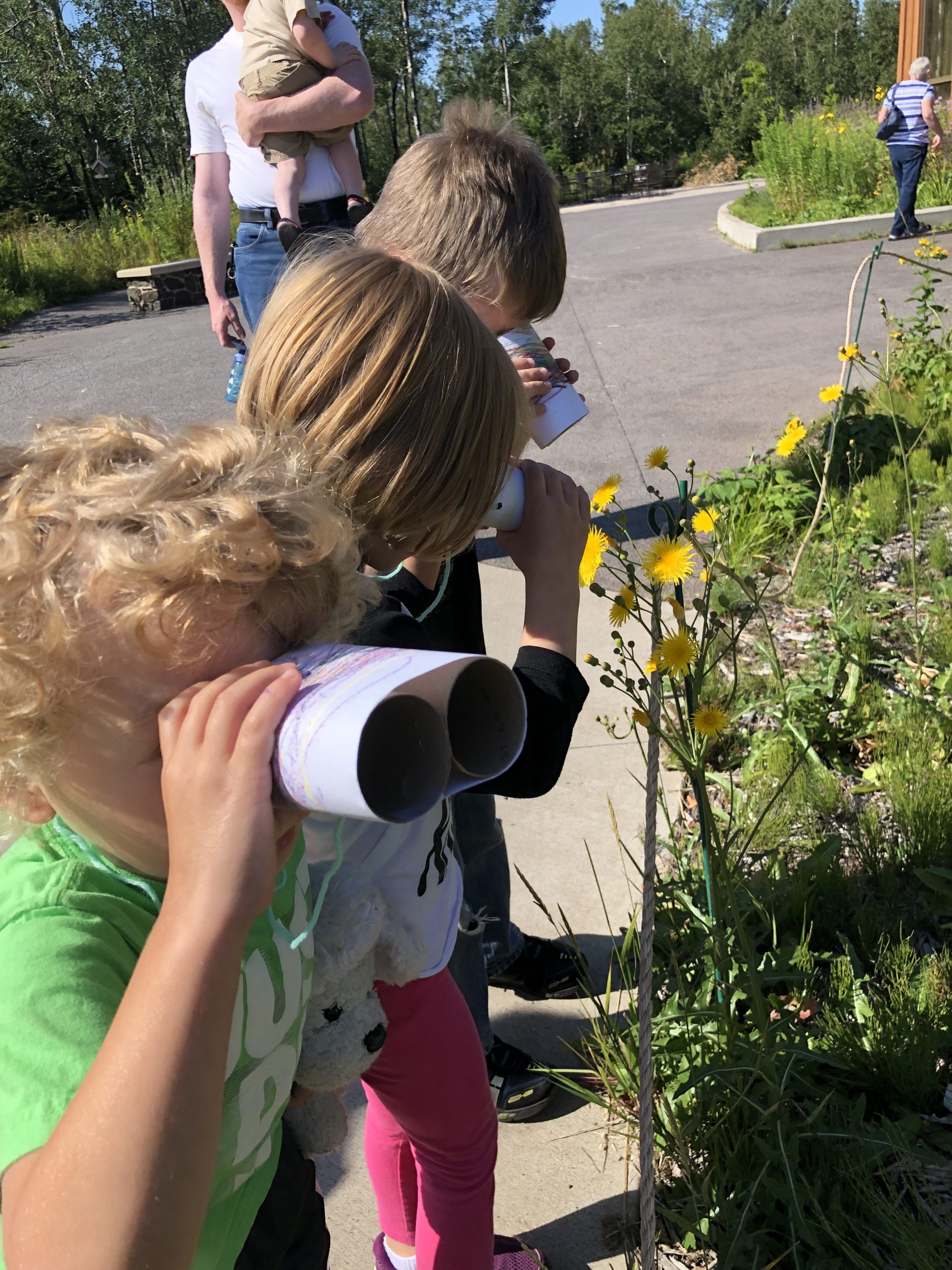 kids look through cardboard roll binoculars