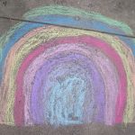 a rainbow in chalk on a sidewalk