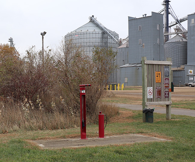 Red bike fix-it station along a trail with silos