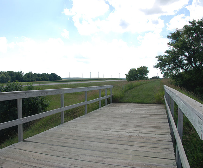 Wooden bridge with grassy area in distance