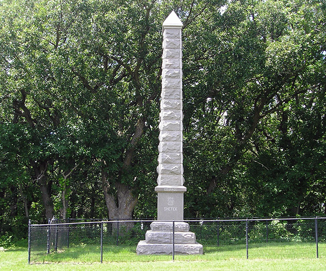 Pillar shaped stone monument in a grassy area