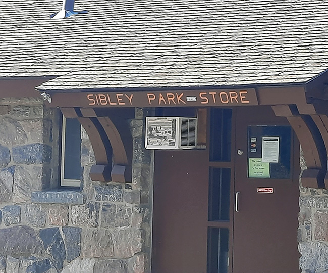 Stone building with roof awning and sign reads Sibley Park Store