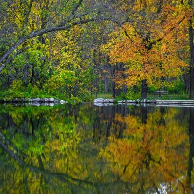 Colorful autumn trees reflecting in lake at Camden State Park