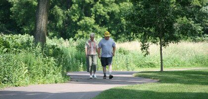 An older couple ambles down the paved bike trail
