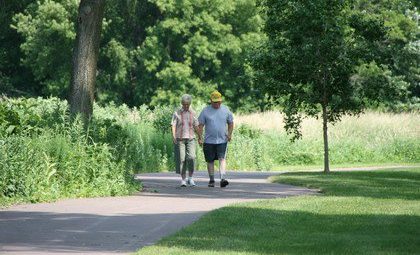 An older couple ambles down the paved bike trail